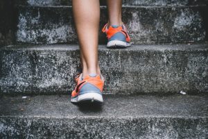 the legs of an individual stepping up stone stairs