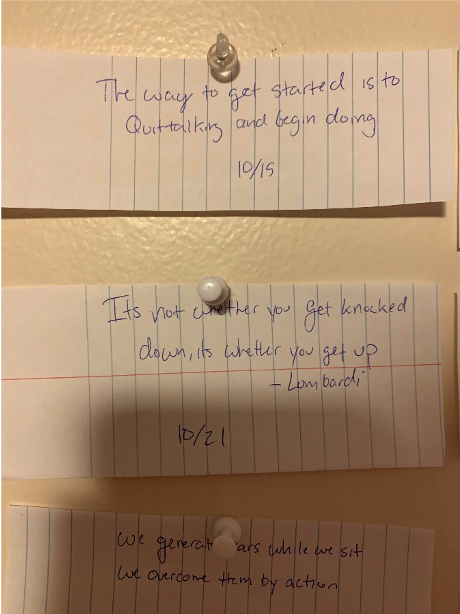Three sheets of paper tacked to the wall. Each has a quote or saying with the date below.
