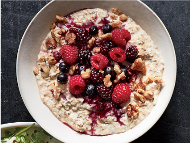 Image of bowl of oatmeal with fresh berries and nuts on top.